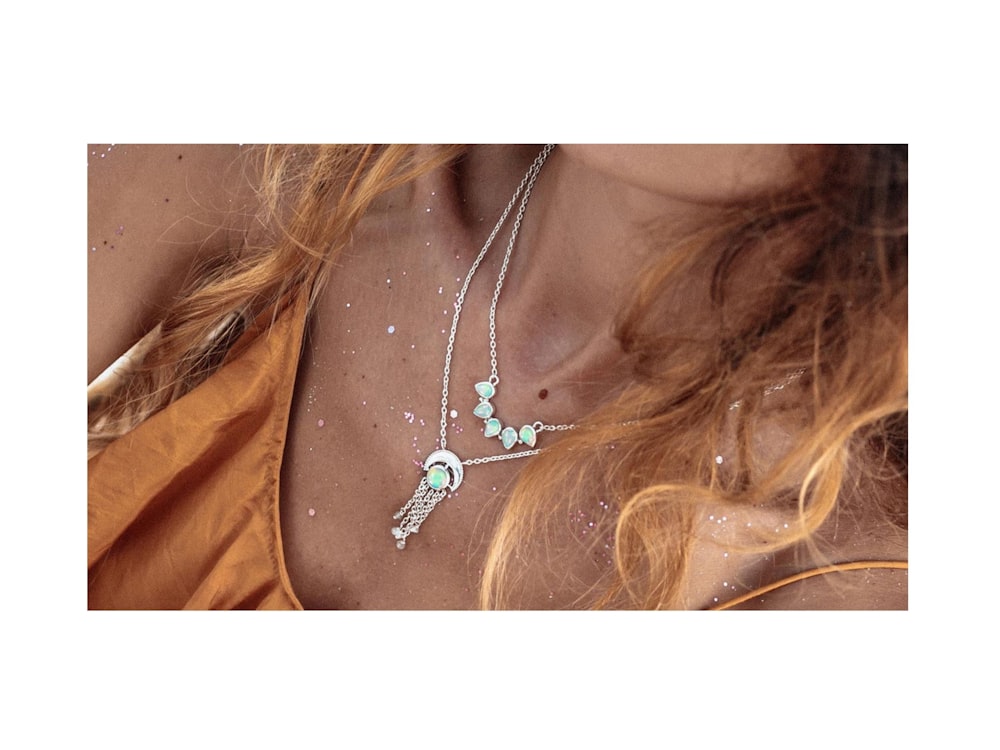 a woman wearing a necklace with a bird on it
