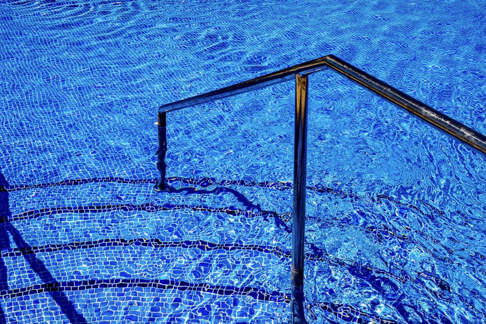 a pool with blue water and a metal railing