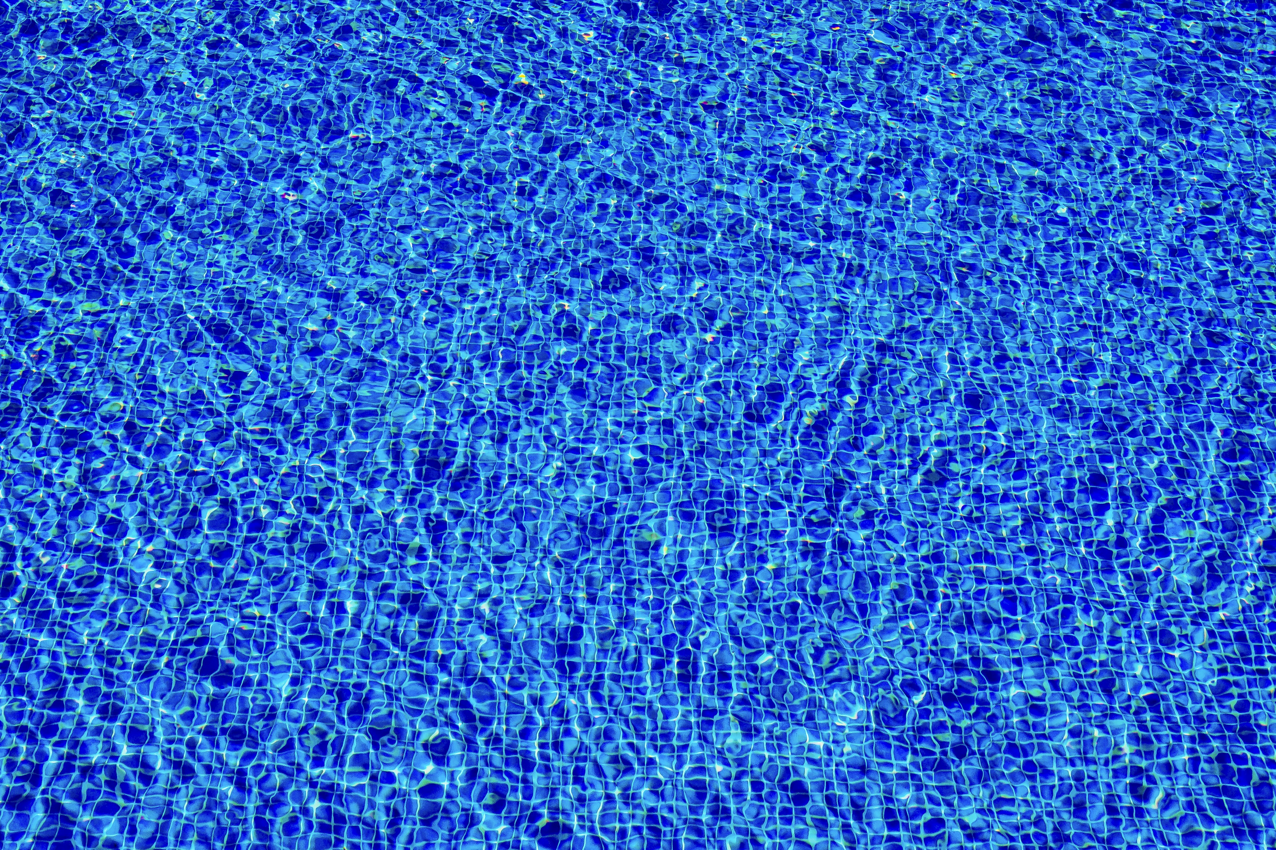 a blue swimming pool with ripples of water