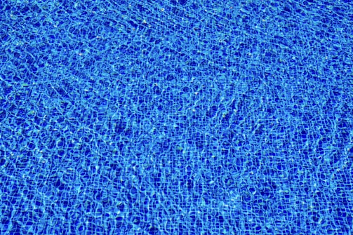 a blue swimming pool with ripples of water
