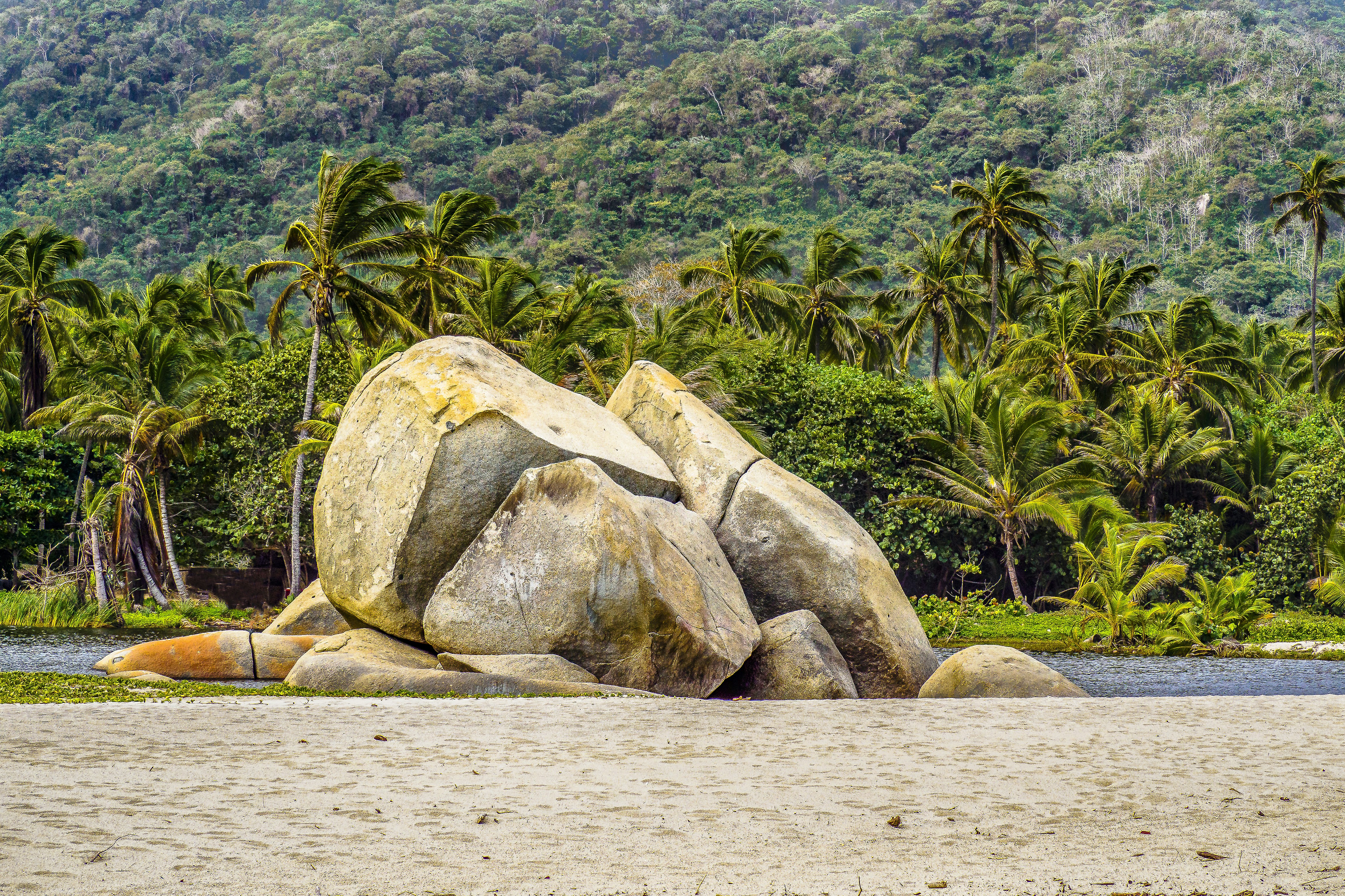 A large rock sitting on top of a sandy beach photo – Free Departamento ...
