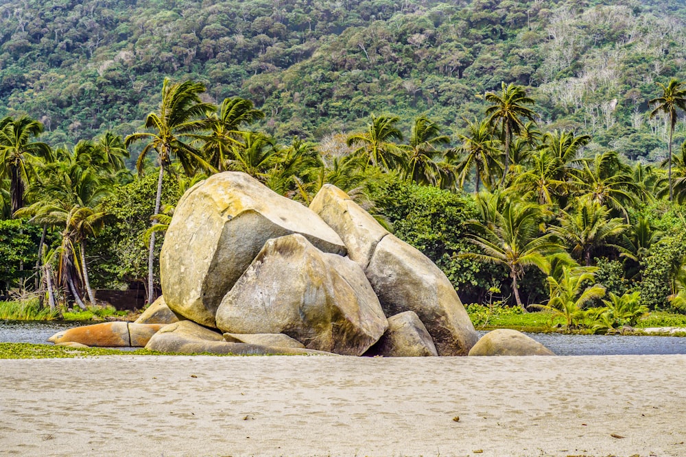 a large rock sitting on top of a sandy beach