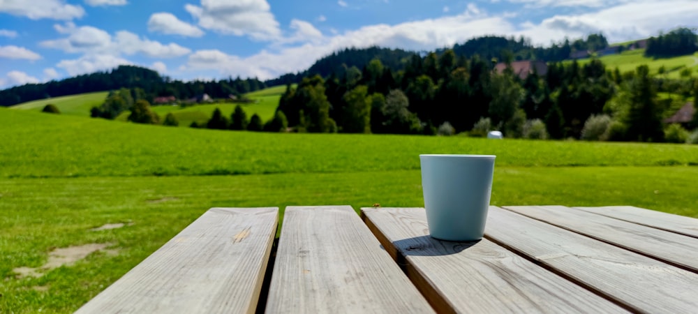 a cup of coffee sitting on top of a wooden table