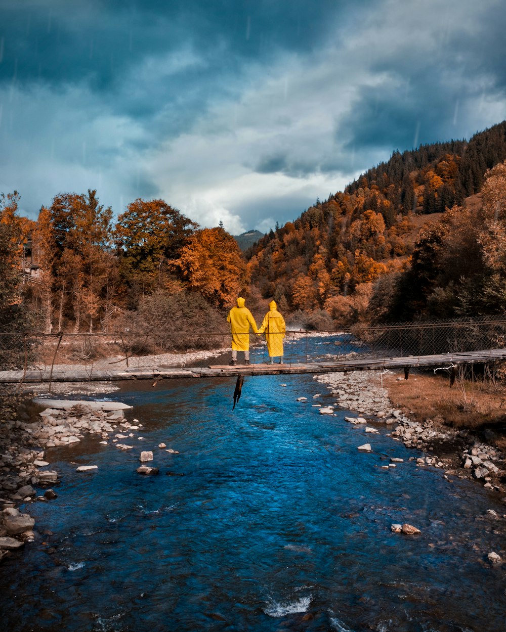 a couple of people standing in the middle of a river