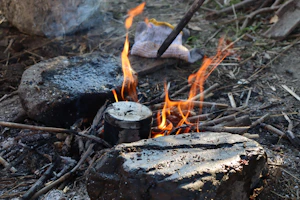 A rugged outdoor scene showing a rockstove cooking pot boiling rapidly over a bright, smokeless fire.