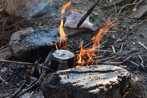 A rugged outdoor scene showing a rockstove cooking pot boiling rapidly over a bright, smokeless fire.