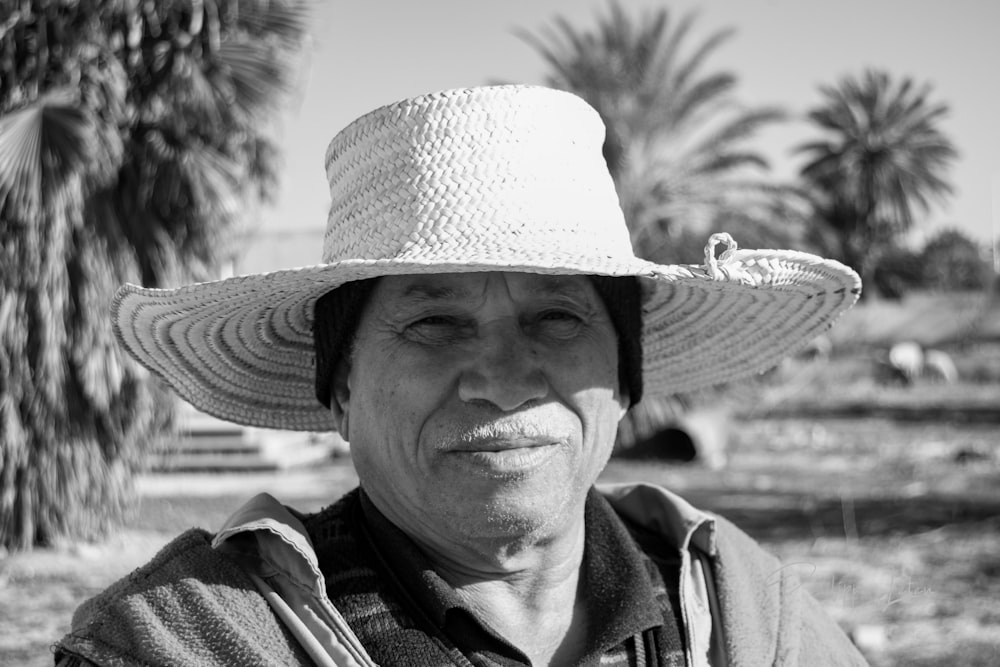 a black and white photo of a man wearing a hat