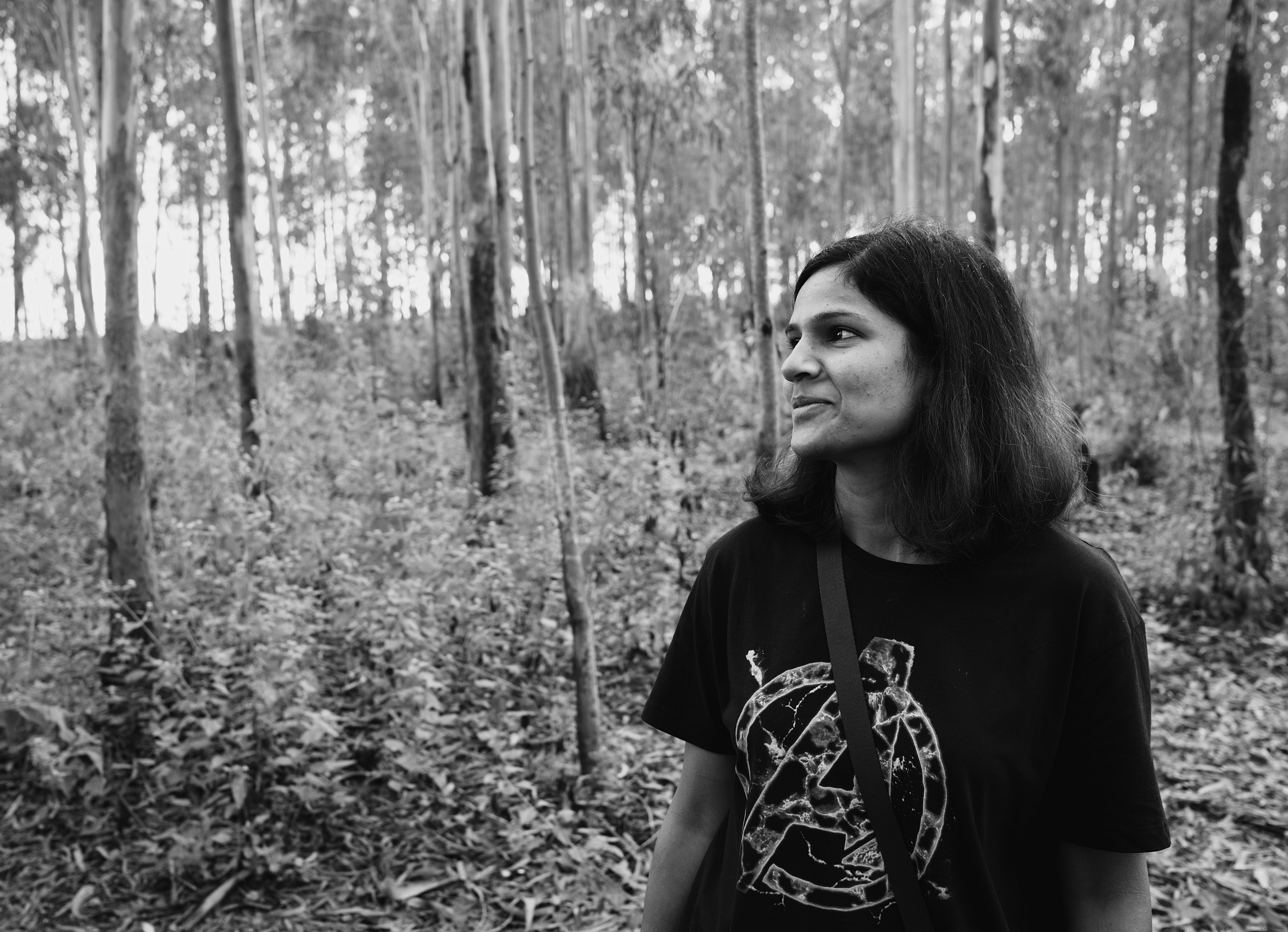 a woman standing in the middle of a forest