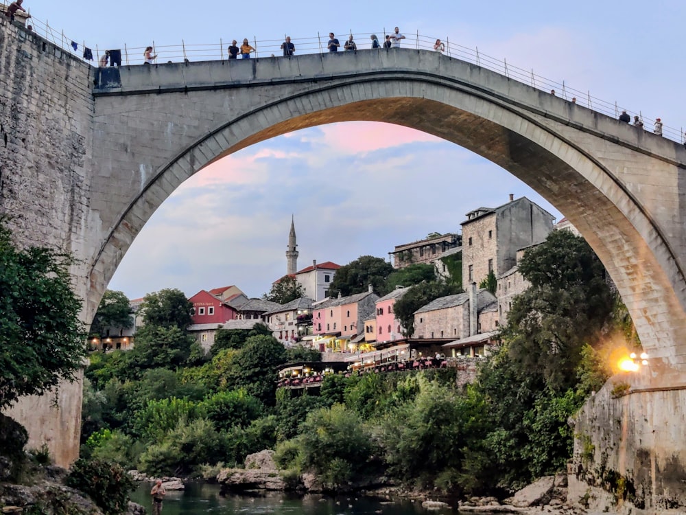 a group of people standing on a bridge over a river