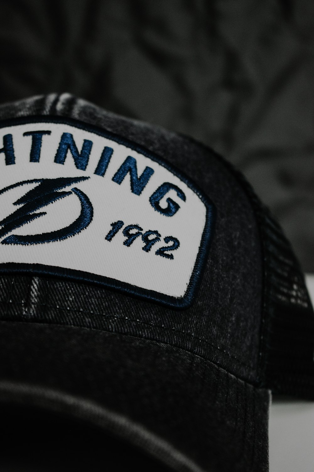 a black hat with a lightning patch on it
