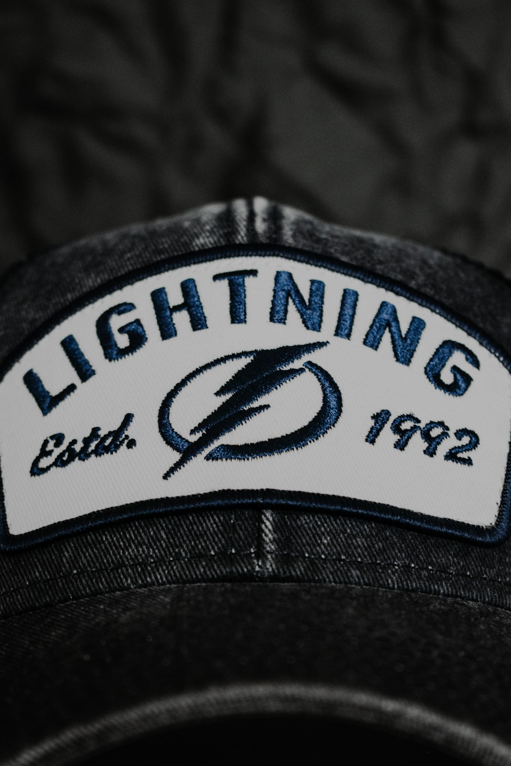 a black hat with a lightning patch on it