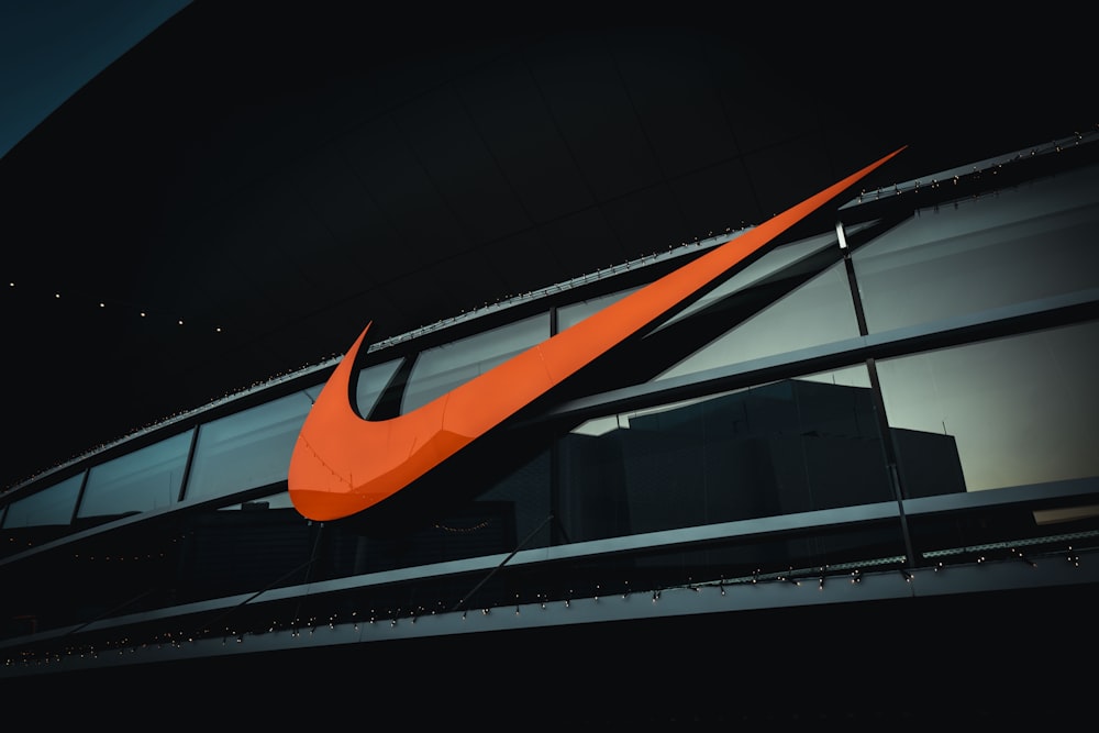 Ein großes orangefarbenes Nike-Logo an der Seite eines Gebäudes