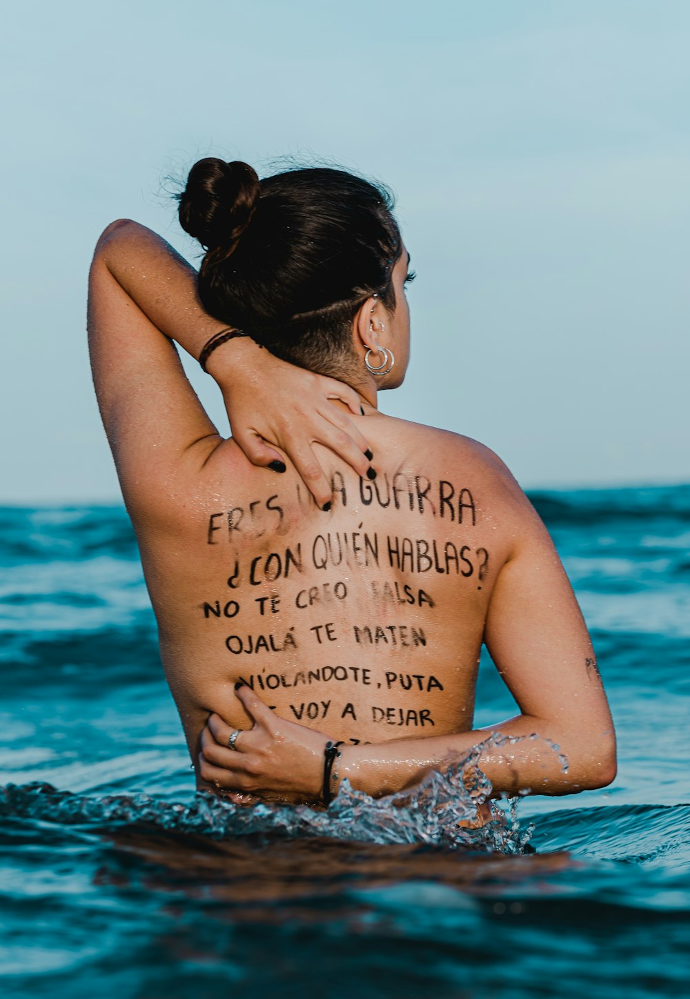 a woman in the ocean with a message written on her back