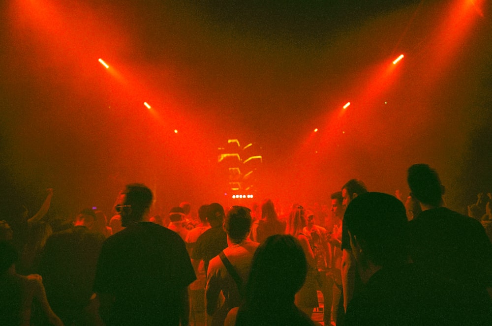 Eine Menschenmenge, die um eine Bühne mit roten Lichtern steht
