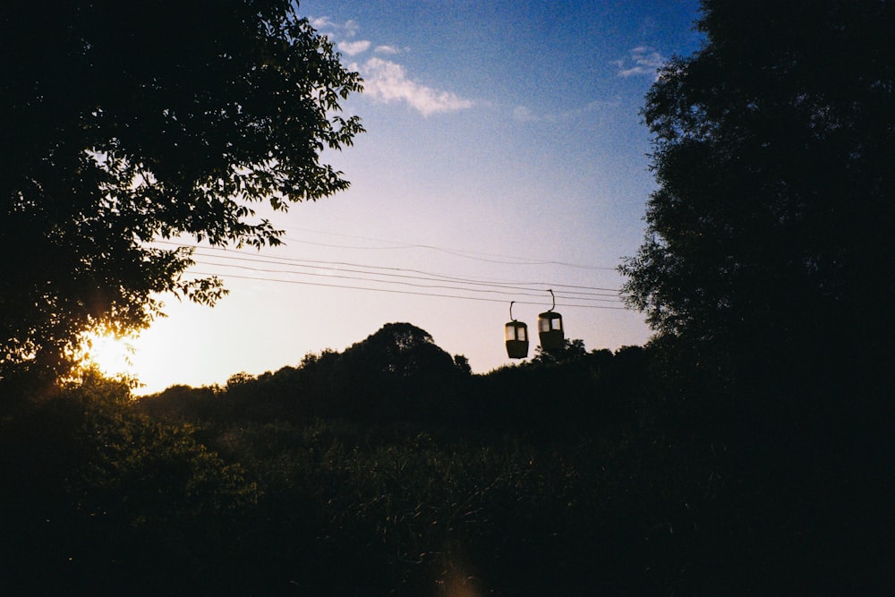 the sun is setting behind some trees