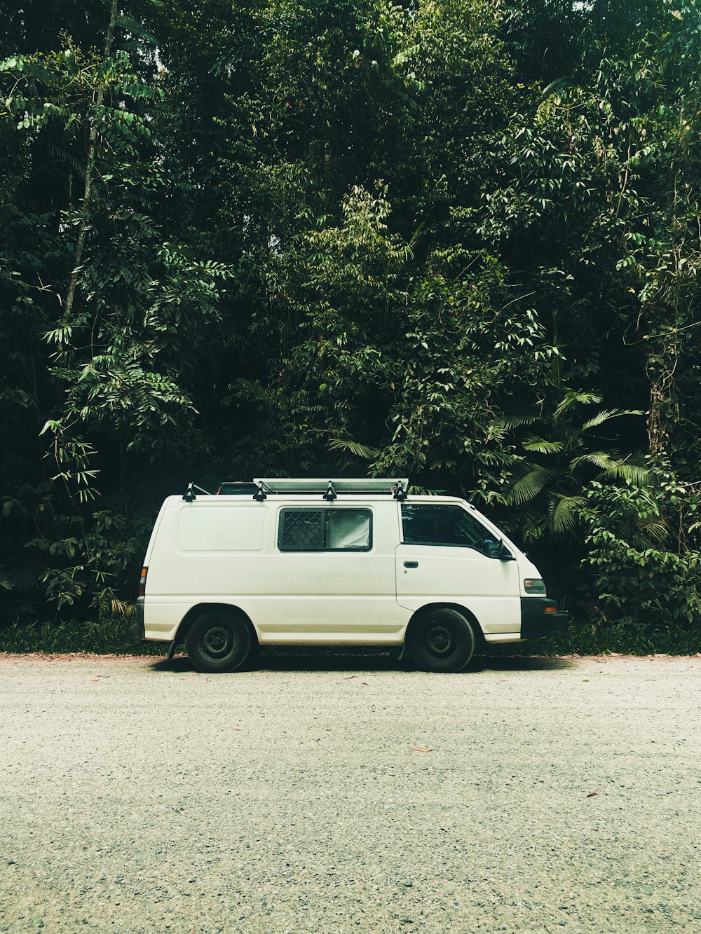 a white van parked in front of a forest