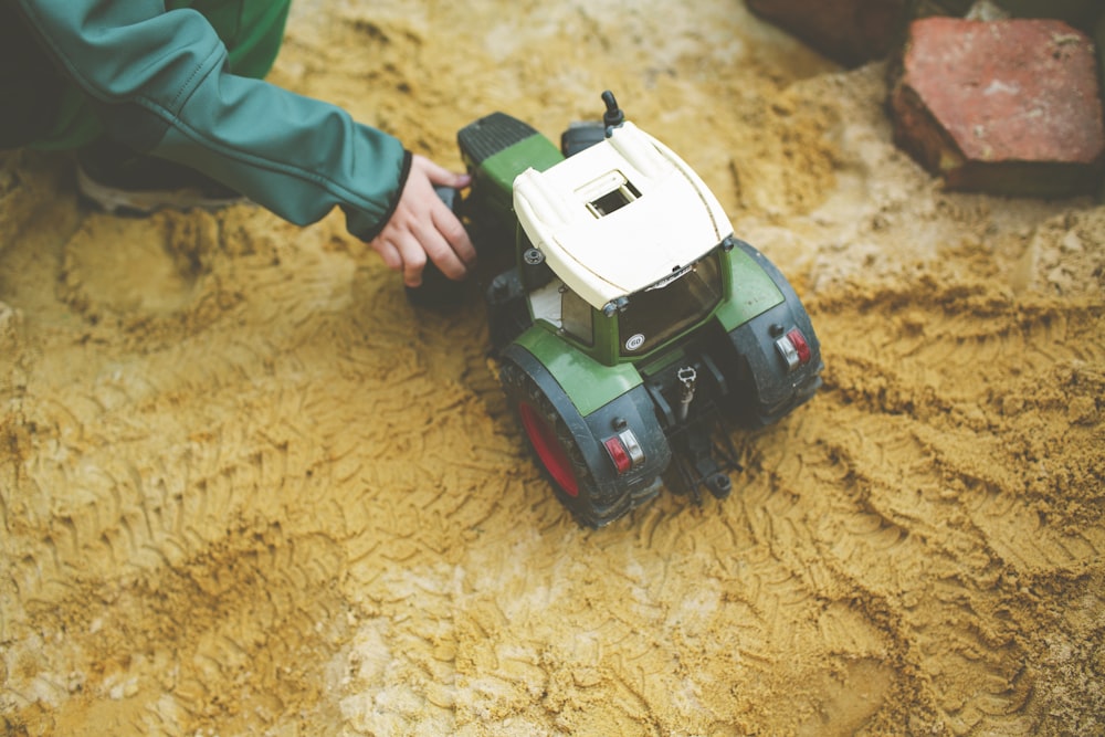 a small toy truck sitting on top of a dirt field