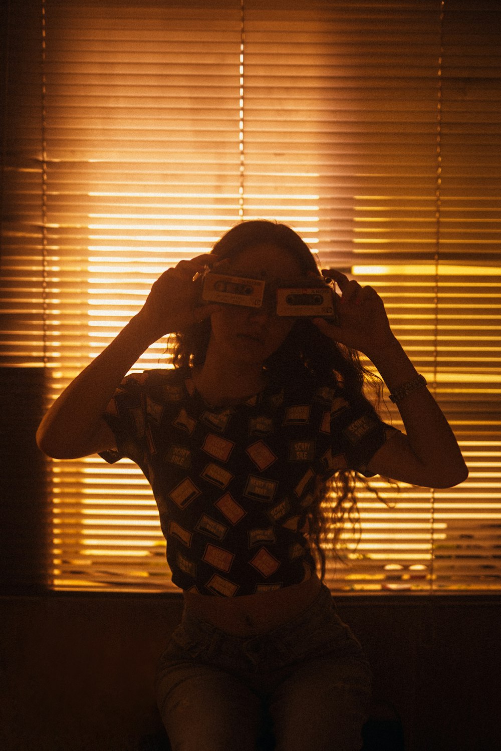 a woman sitting in front of a window with a pair of 3d glasses on her