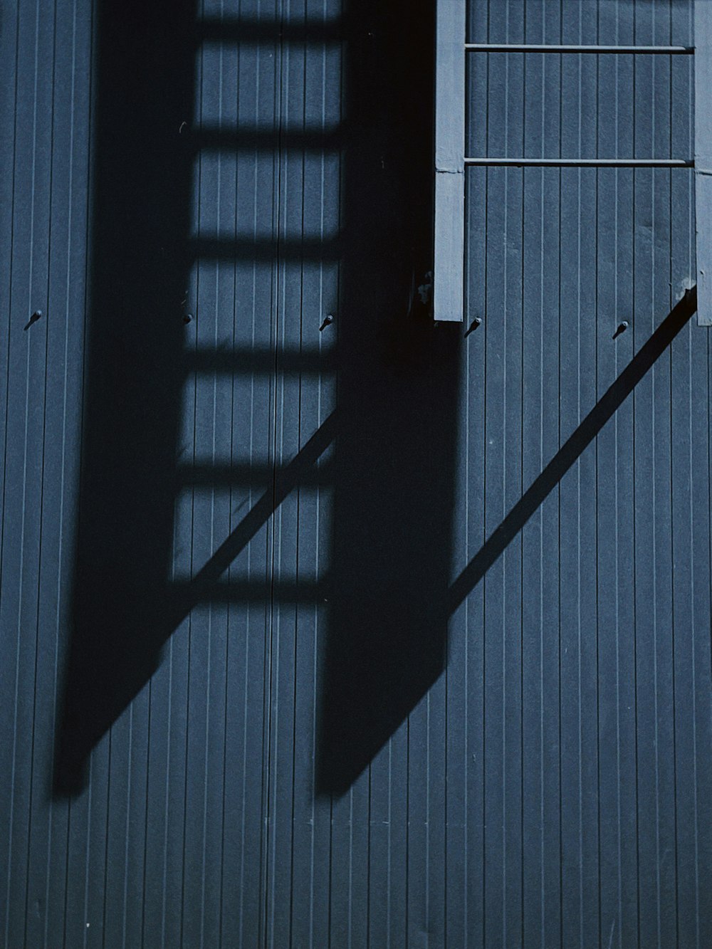 a shadow of a ladder on a building