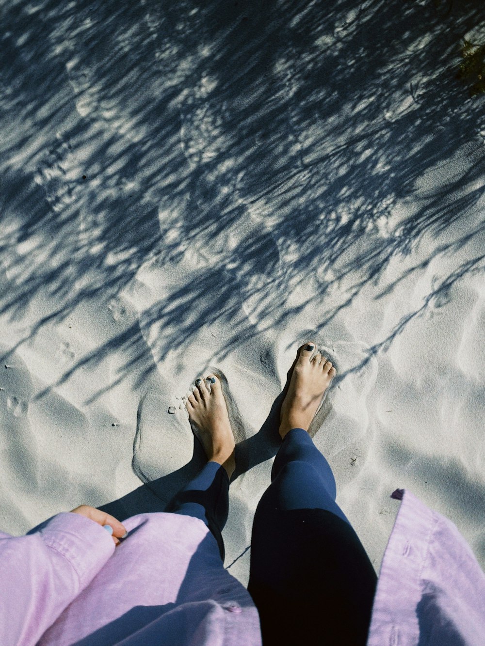 a person laying in the sand with their feet up