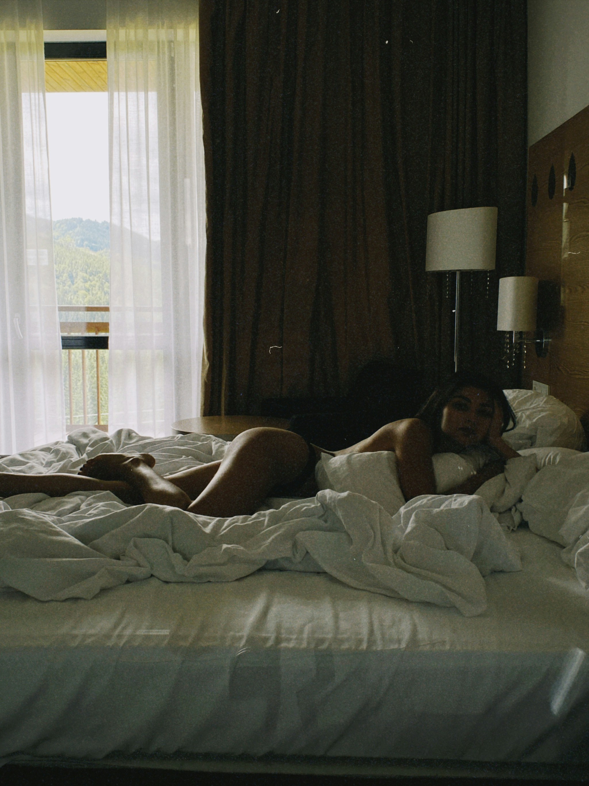 a woman laying on a bed in a hotel room