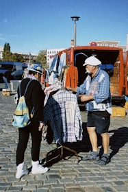 a man and a woman standing next to each other in front of a truck