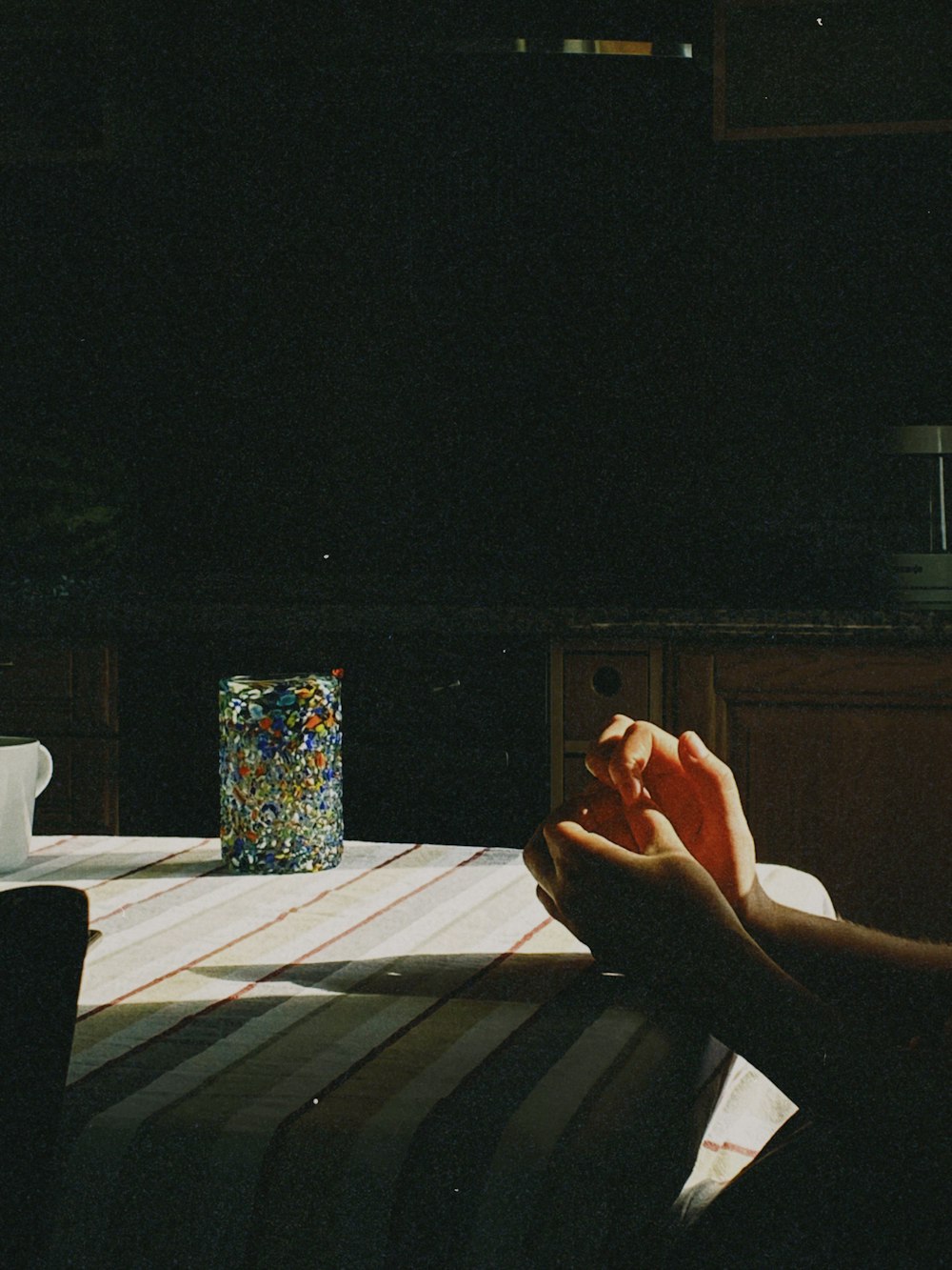 a person sitting at a table in the dark