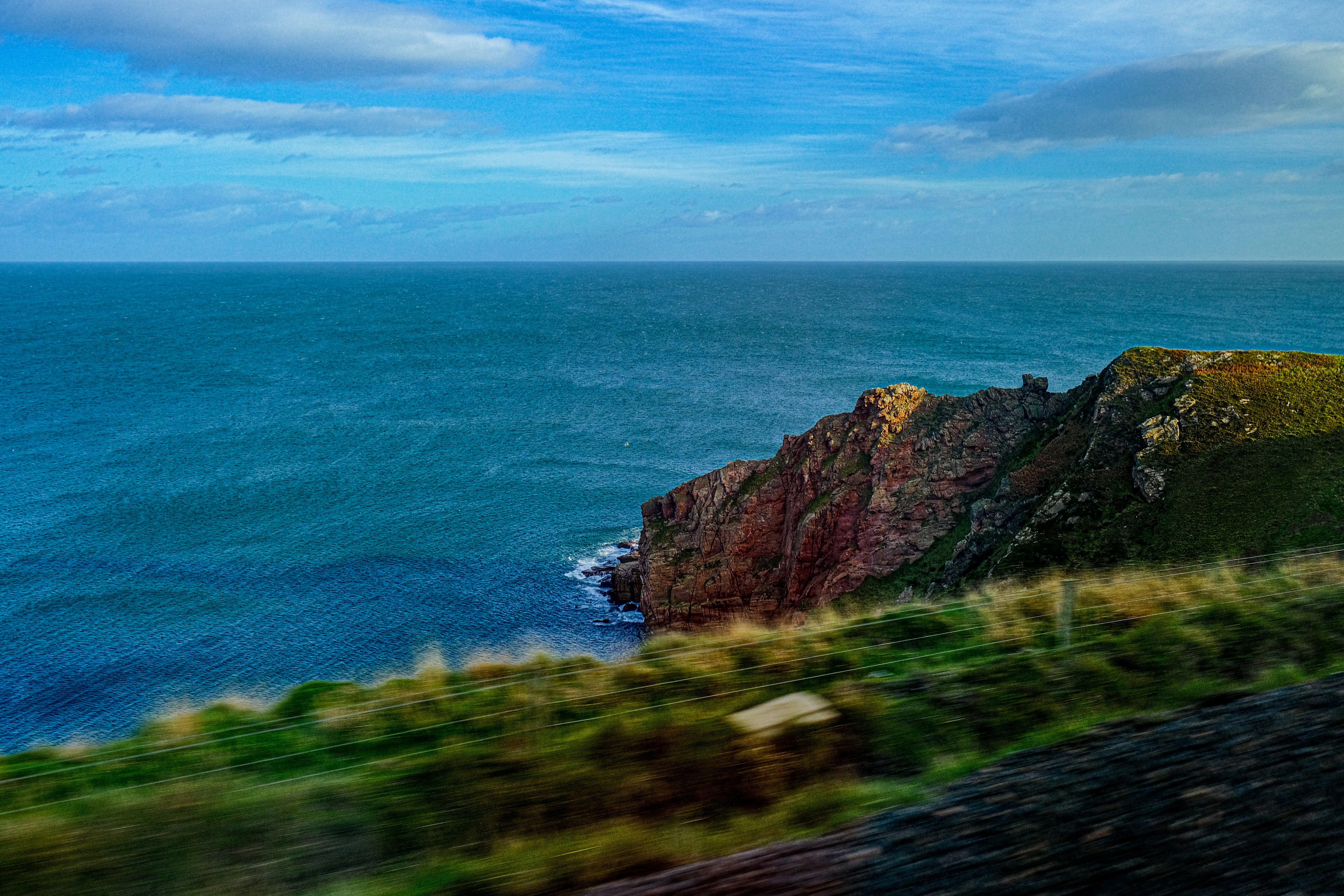 a view of the ocean from a moving train