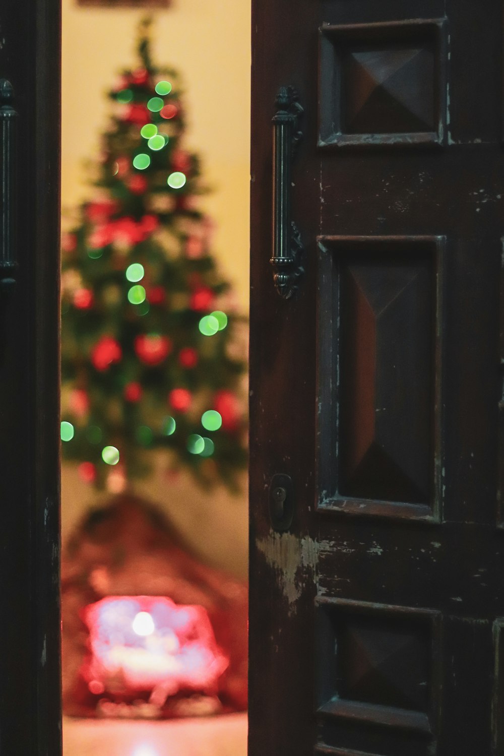 a view of a christmas tree through an open door