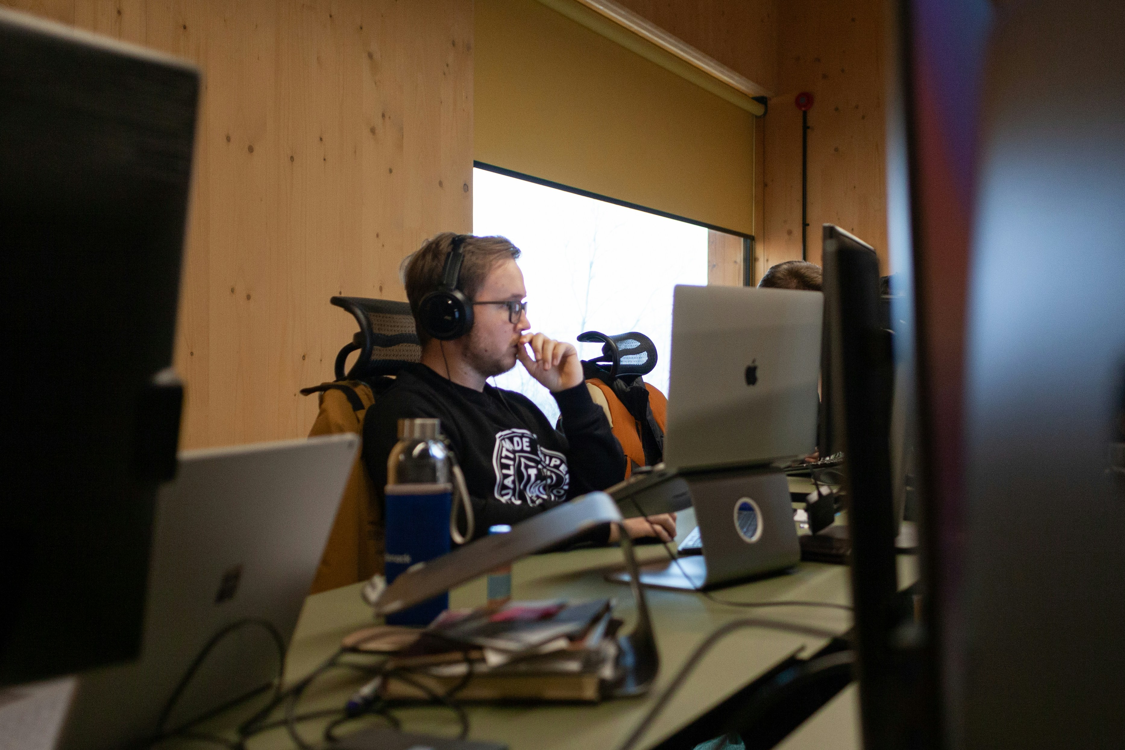 Seorang pria duduk di meja dengan headphone