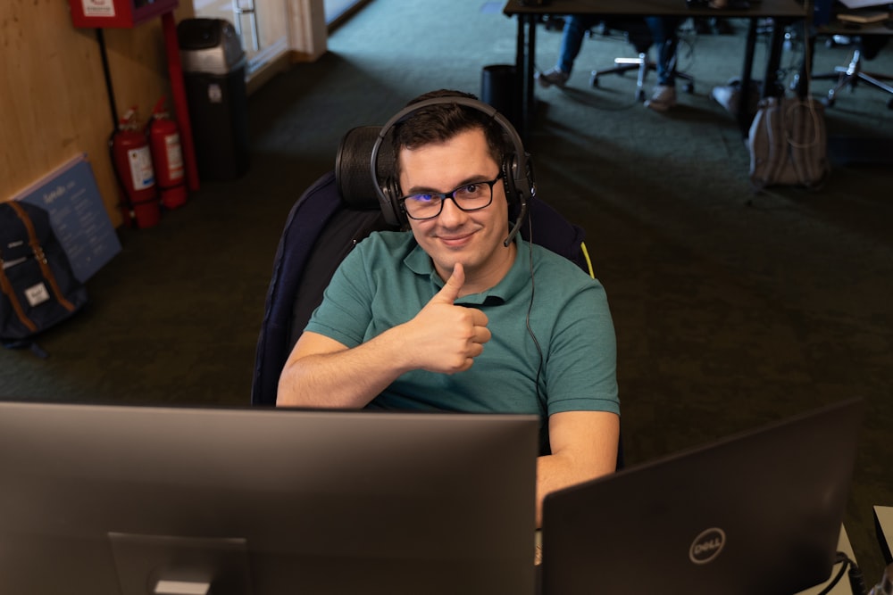 a man wearing headphones sitting in front of a computer