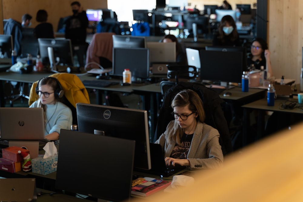 a group of people working on laptops in an office