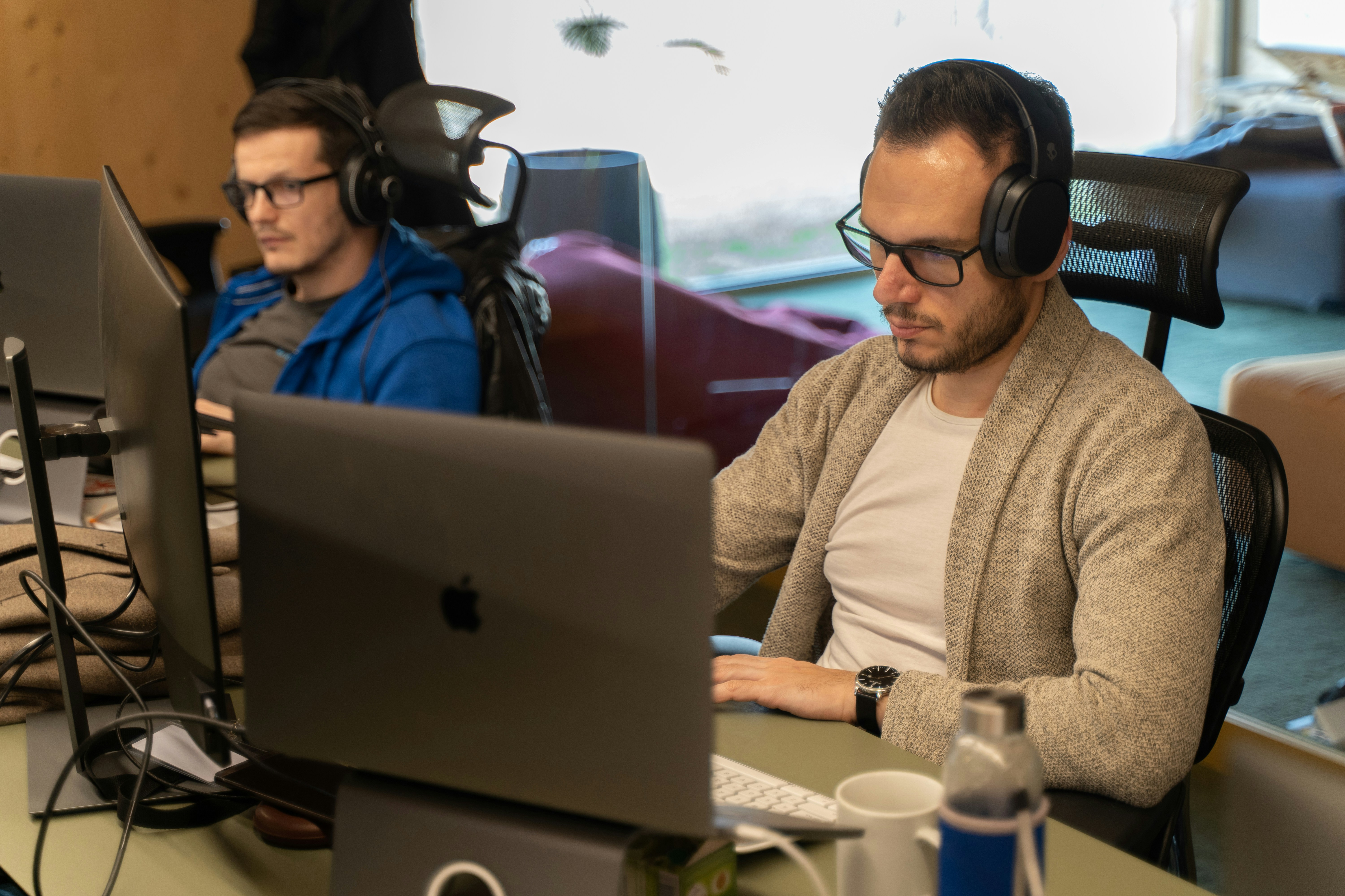 Un hombre sentado frente a una computadora portátil con auriculares