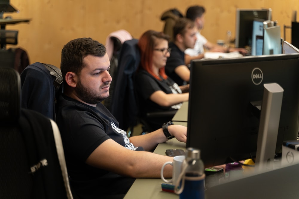 a man sitting in front of a computer monitor