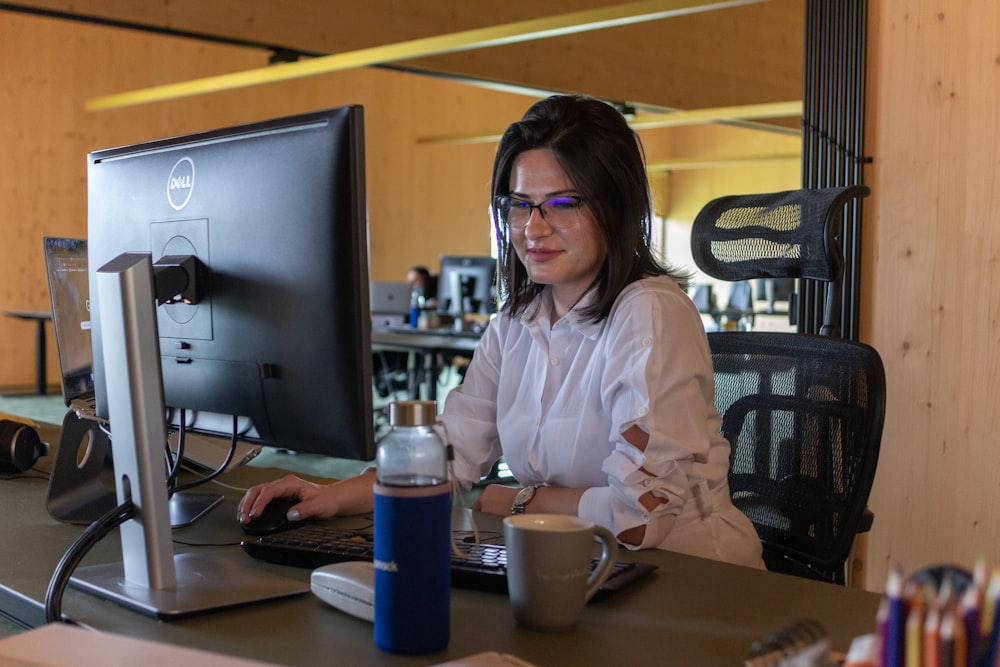 a woman sitting at a desk in front of a computer