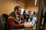 A focused freelancer setting up multiple computer workstations in a modern office.