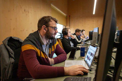 A focused freelancer setting up multiple computer workstations in a modern office.