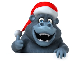 A cartoonish gorilla character wearing a red Santa hat with a white pom-pom, appearing cheerful and giving a thumbs up gesture. The gorilla has a big, toothy smile and lively blue eyes.