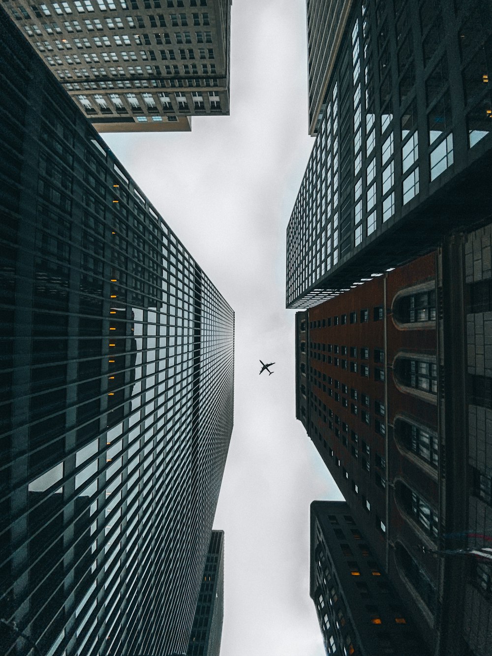an airplane flying through the air between two buildings
