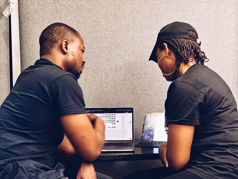 a couple of people sitting at a table with a laptop