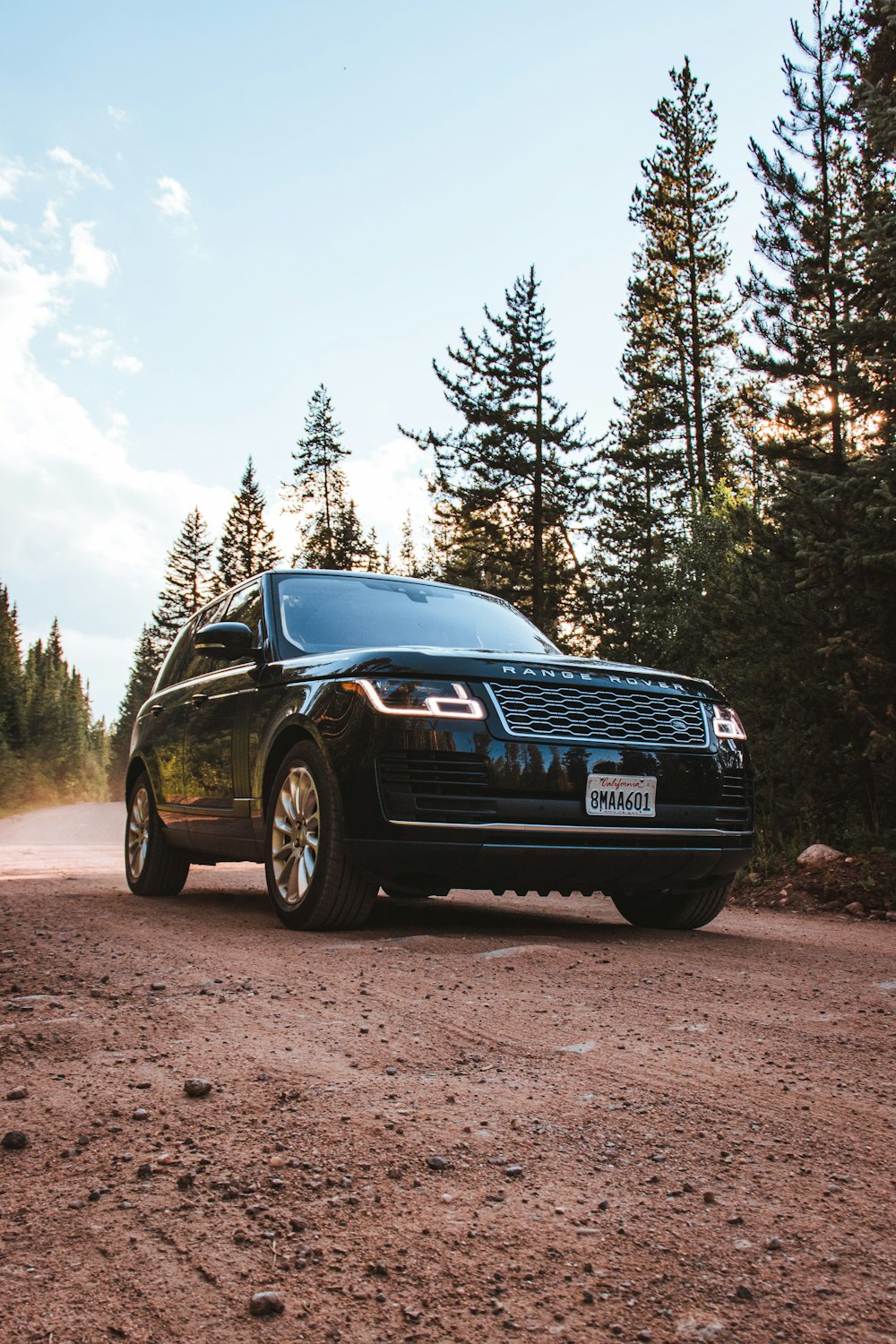 a black suv parked on a dirt road