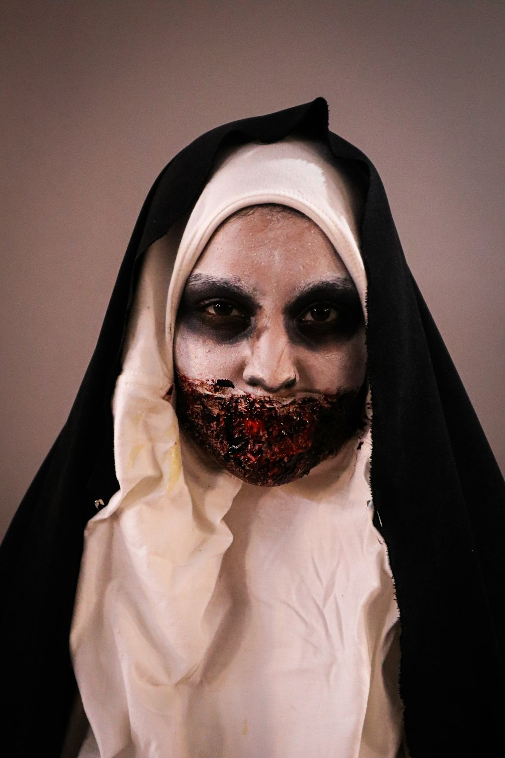 a man in a nun costume with blood on his face