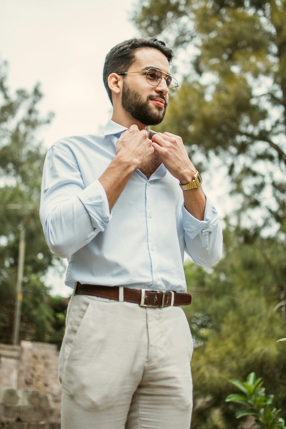 a man wearing a blue shirt and tan pants