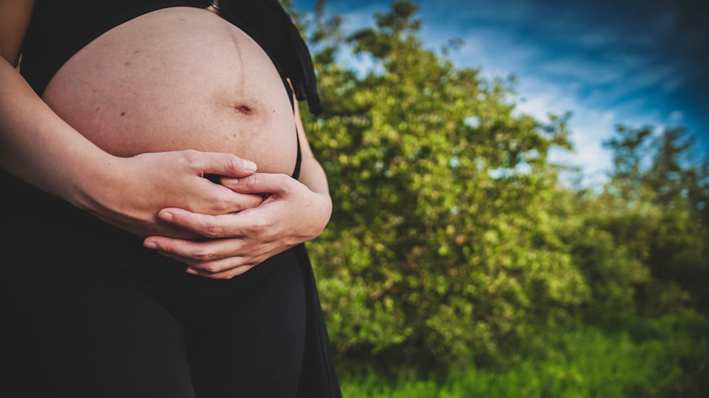 a pregnant woman holding her belly in her hands