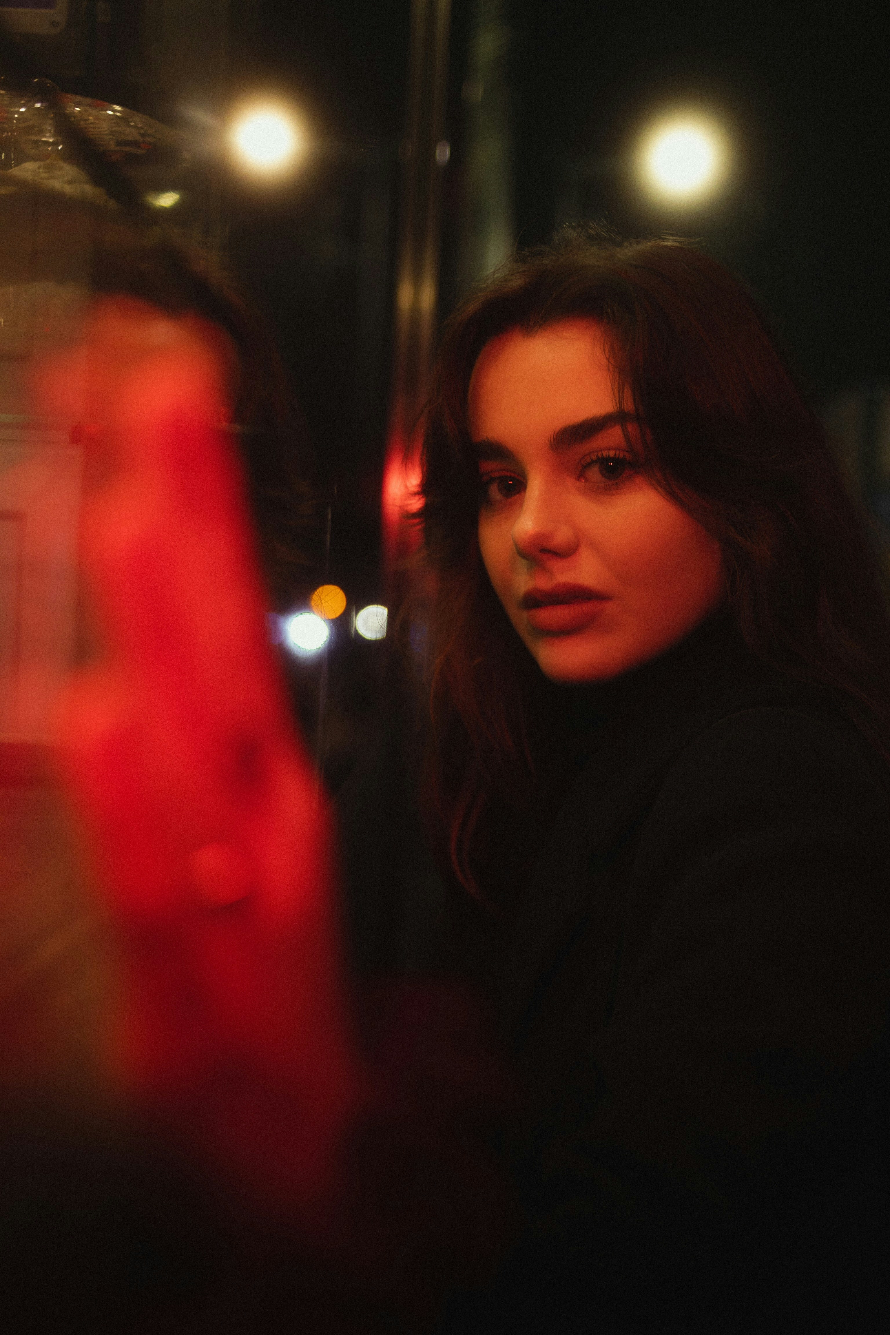 a woman standing in front of a red light