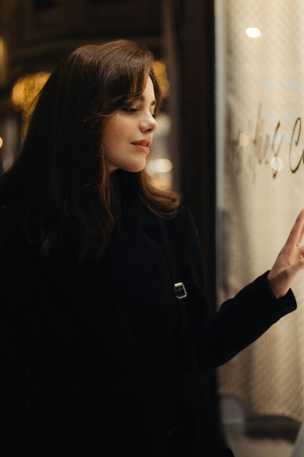 a woman standing in front of a store window