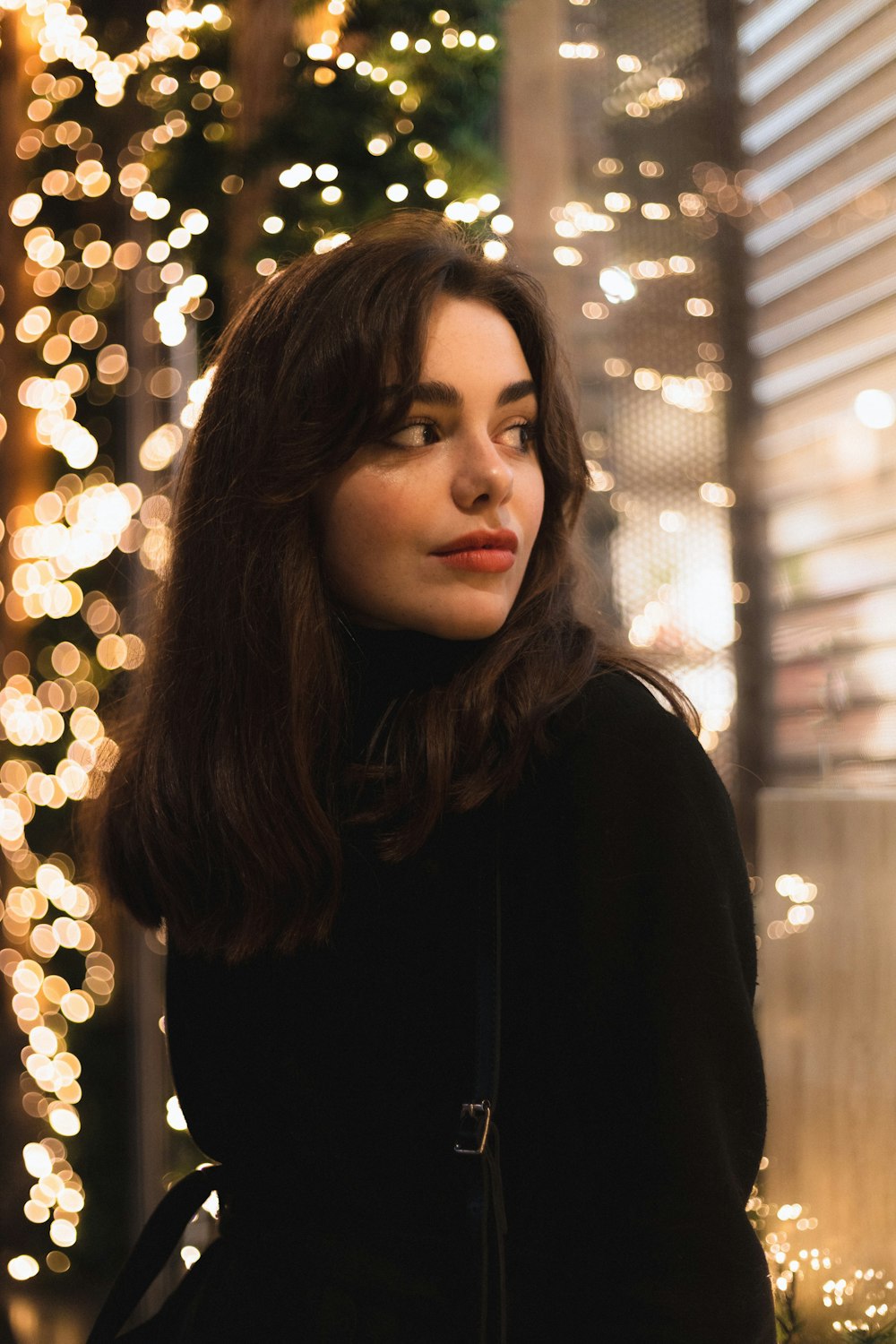 a woman standing in front of a christmas tree