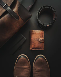 a pair of shoes, a wallet, and a belt laid out on a table