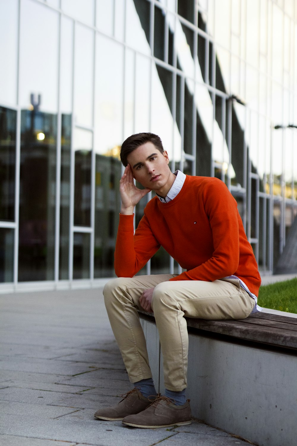 a man sitting on a bench in front of a building