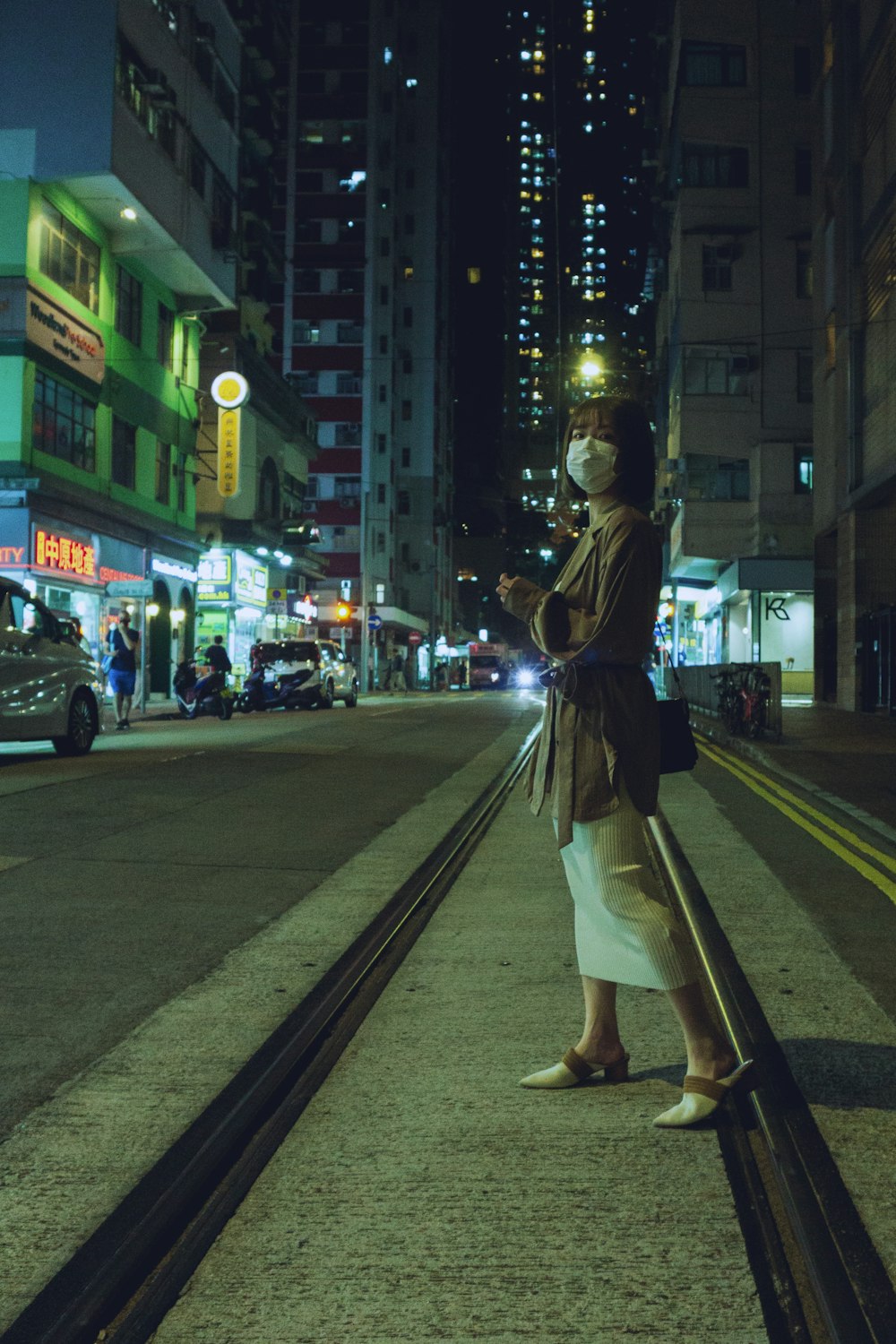 a woman standing on a train track at night